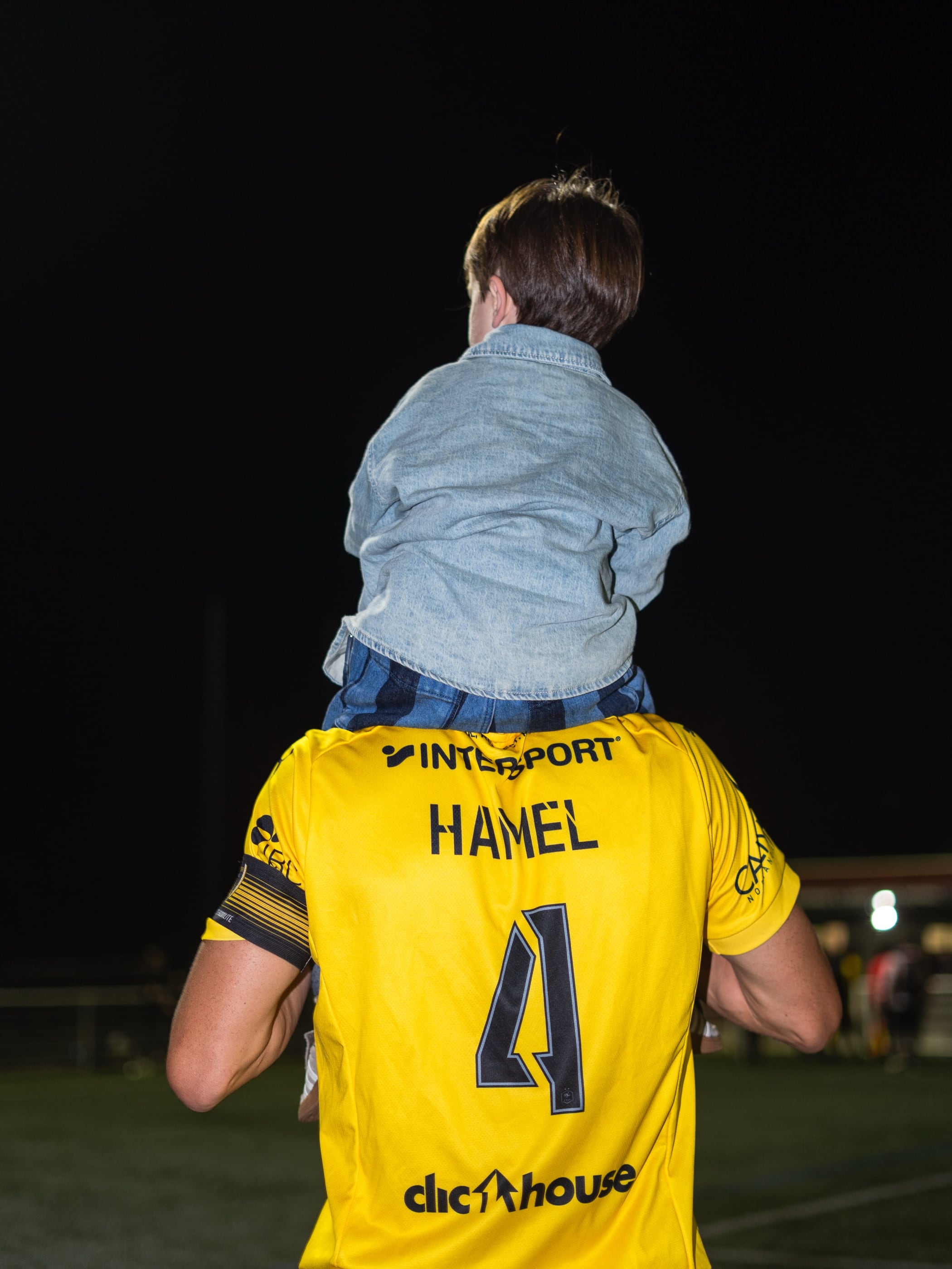 Le capitaine Léo Hamel, maillot jaune n° 4, porte un jeune supporter sur ses épaules après le match